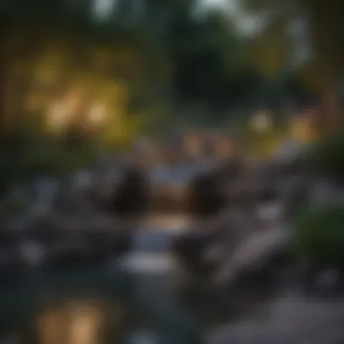 Dusk view of a backyard waterfall illuminated by soft lights